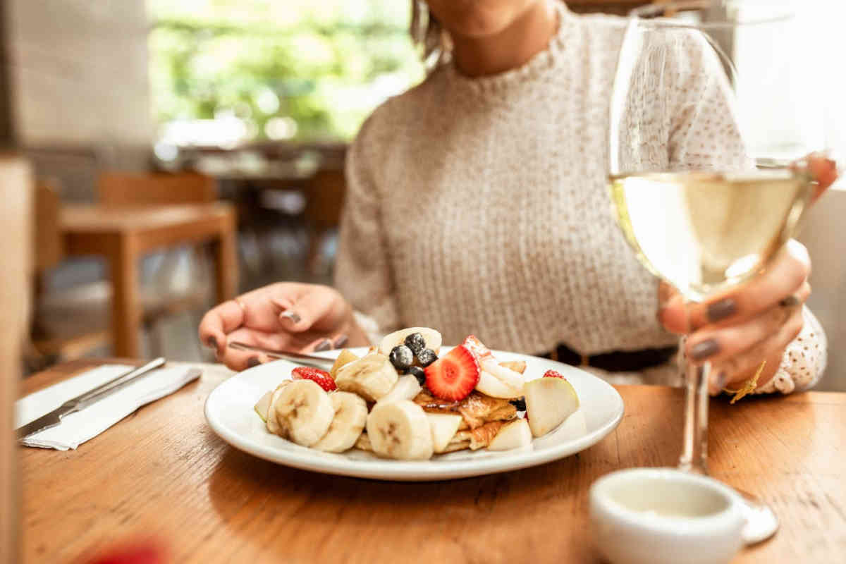 Ragazza che mangia banane e altra frutta