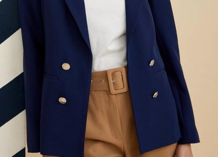 ragazza con pantalone marrone, t-shirt bianca e blazer blu