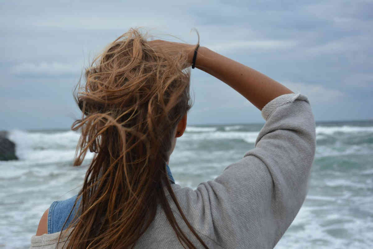 Ragazza di spalle in riva al mare