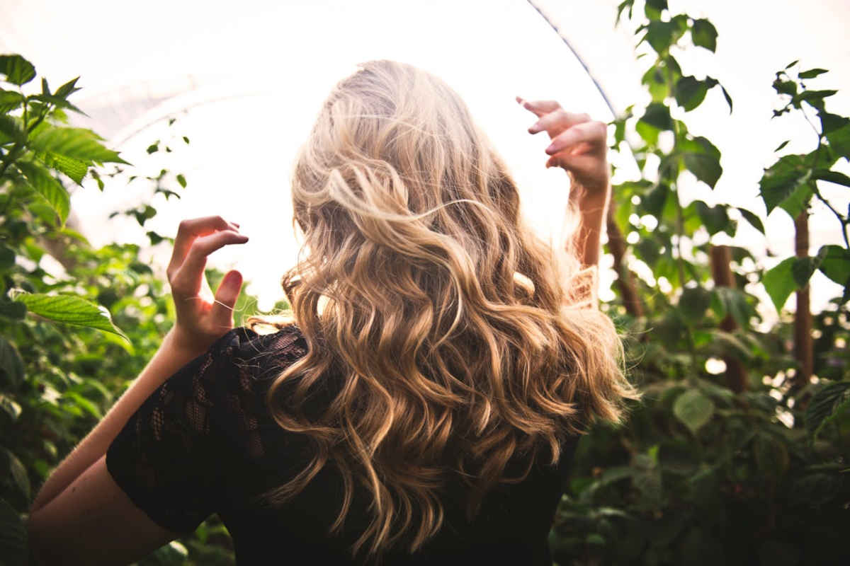 Ragazza con capelli biondi sciolti di spalle